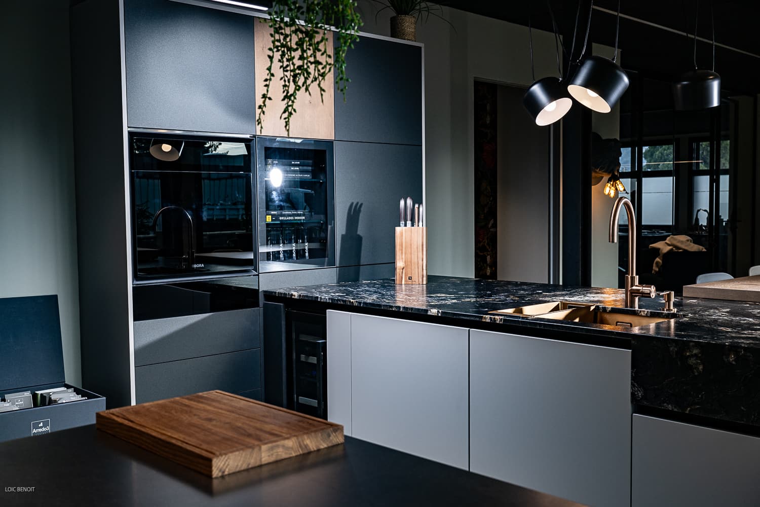 Cuisine moderne avec îlot, grande baie vitrée et éclairage chaleureux